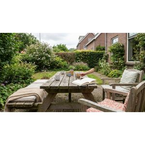 Gezellige tuin met houten tafel en koffiekopjes