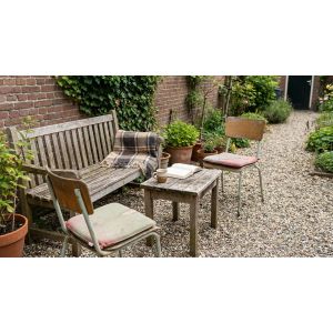 Gezellige tuin met houten bank en koffietafel
