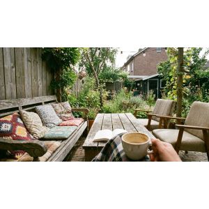 Gezellige tuin met houten meubels en koffie