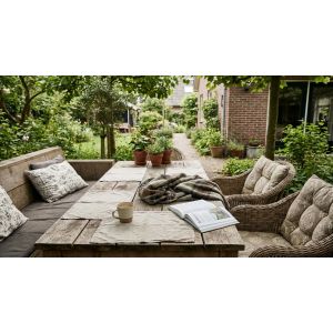Gezellige tuin met houten tafel en zithoek