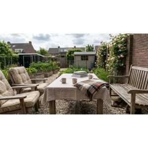 Gezellige achtertuin met tafel, stoelen en moestuin