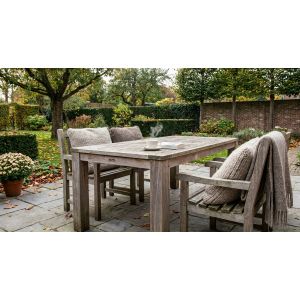 Houten tuintafel met stoelen in herfsttuin